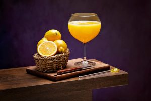 Vibrant citrus display with freshly squeezed orange juice in an elegant glass.